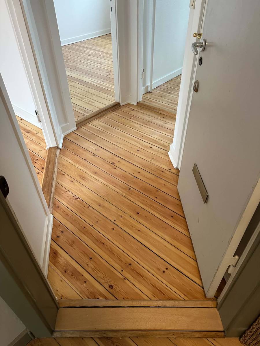 Efter: lyst, nyslebet plankegulv i entré